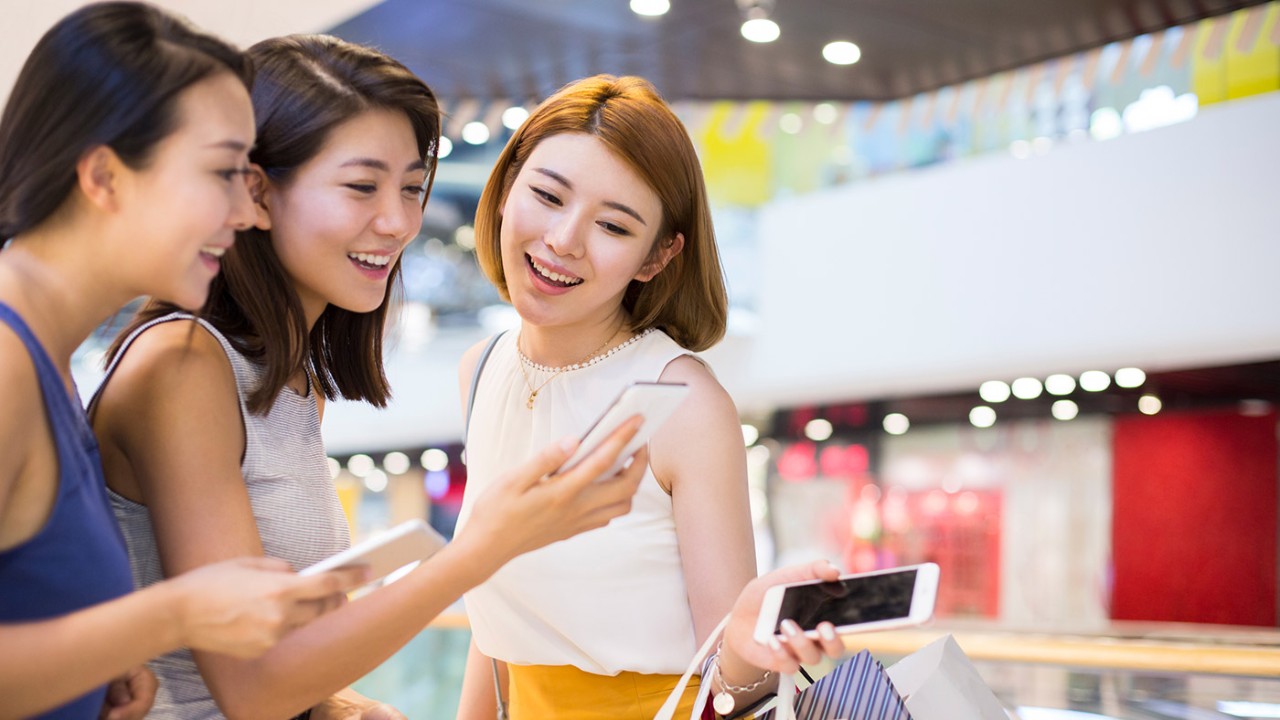 Friends smiling and looking at phone; image used for HSBC Philippines Visa Offers page